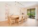 A stylish dining room with large table, seating for twelve, unique mural, and sliding glass doors at 1445 Rolling Fairway Dr, Davenport, FL 33896