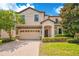 Charming two-story home featuring a brick driveway, two-car garage, and lush landscaping at 1445 Rolling Fairway Dr, Davenport, FL 33896