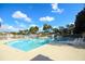 Community pool area featuring comfortable lounge chairs, clear blue water, and palm trees at 164 Reserve Cir # 208, Oviedo, FL 32765