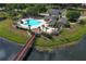 Aerial view of a community pool, clubhouse, sundeck, pond, and scenic wooden bridge at 164 Reserve Cir # 208, Oviedo, FL 32765