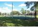 View of the community tennis court with a fence, net, and well maintained grass at 164 Reserve Cir # 208, Oviedo, FL 32765