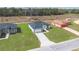 Aerial view of a modern home with a long driveway and well-manicured lawn in a vibrant neighborhood at 17046 Sw 44Th Cir, Ocala, FL 34473