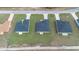 Aerial view of neighborhood homes with dark roofs and well-manicured lawns under a sunny sky at 17046 Sw 44Th Cir, Ocala, FL 34473