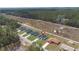 Aerial view of a single-story home nestled amongst trees with a gravel road nearby at 17046 Sw 44Th Cir, Ocala, FL 34473