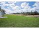 Expansive backyard featuring lush green grass and power lines in the distance of the property at 17046 Sw 44Th Cir, Ocala, FL 34473