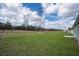 Expansive backyard featuring lush green grass and power lines in the distance of the property at 17046 Sw 44Th Cir, Ocala, FL 34473