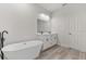 Bright bathroom featuring a soaking tub, dual sink vanity, and wood-look tile flooring at 17046 Sw 44Th Cir, Ocala, FL 34473