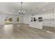 Open concept living room with a kitchen, large sliding glass doors, and wood grain flooring at 17046 Sw 44Th Cir, Ocala, FL 34473