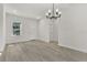 Bright living room with light hardwood floors, a modern chandelier, and white trim at 17046 Sw 44Th Cir, Ocala, FL 34473