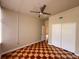 A bedroom offering a neutral palette with white closet doors and fan, plus checkered wood floors at 202 S Hampton Ave, Orlando, FL 32803