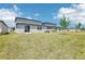 Backyards of multiple homes with green grass, neutral exteriors and some small trees at 2094 Rosewood Dr, Bartow, FL 33830
