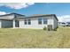 A view of the backyard with a white house and green grass under a blue sky at 2094 Rosewood Dr, Bartow, FL 33830