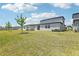 A vast backyard featuring healthy green grass, complete with a neutral-colored home with a sliding glass door at 2094 Rosewood Dr, Bartow, FL 33830