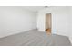 An airy bedroom with gray carpet, white walls, and an entrance to the bathroom at 2094 Rosewood Dr, Bartow, FL 33830