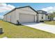 Home featuring a large garage, manicured lawn and landscaping at 2094 Rosewood Dr, Bartow, FL 33830