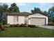 Charming single-story home featuring a two-car garage, stucco exterior, and beautifully landscaped front yard at 2094 Rosewood Dr, Bartow, FL 33830