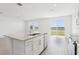 Bright kitchen featuring a central island, granite counters, stainless steel appliances, and a lake view through large windows at 2094 Rosewood Dr, Bartow, FL 33830