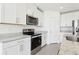 Well-equipped kitchen with stainless steel appliances, granite countertops, and sleek white cabinetry at 2094 Rosewood Dr, Bartow, FL 33830