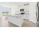 Modern kitchen features stainless appliances, a central island, and a view of the backyard lake through sliding glass doors at 2094 Rosewood Dr, Bartow, FL 33830