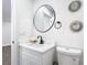 A modern bathroom featuring a round mirror, white vanity with marble countertop, and stylish decorations at 2411 Crawford Dr, Sanford, FL 32771