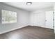 Simple bedroom with wood floors, natural light through the window, and a closet, creating a cozy atmosphere at 2411 Crawford Dr, Sanford, FL 32771