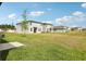 Expansive backyard features lush lawn and young tree, offering privacy and room to roam at 2511 Linda Knoll Ln, Bartow, FL 33830