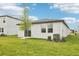 Well-maintained backyard has green lawn, young tree, and neat landscaping with AC unit at 2511 Linda Knoll Ln, Bartow, FL 33830