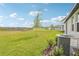 Large backyard features a green lawn, young tree, and view of a pond in a friendly neighborhood at 2511 Linda Knoll Ln, Bartow, FL 33830