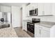 Modern kitchen features stainless steel appliances, white cabinets, and granite countertops at 2511 Linda Knoll Ln, Bartow, FL 33830