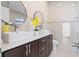 Bright bathroom with double sinks, stylish mirrors, and modern fixtures and neutral tile backsplash at 2524 Monaco Cove Cir, Orlando, FL 32825