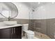 Updated bathroom featuring modern fixtures, gray tile accents, walk-in shower, and decorative mirror at 2524 Monaco Cove Cir, Orlando, FL 32825