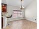 Open dining area featuring tiled floors, a chandelier, and seamless kitchen access at 2524 Monaco Cove Cir, Orlando, FL 32825