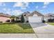 Charming single-story home with a well-manicured lawn, mature landscaping, and a two-car garage at 2524 Monaco Cove Cir, Orlando, FL 32825