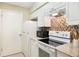 Bright kitchen with white appliances, granite countertops, and tiled backsplash at 3004 Parkway Blvd # 203, Kissimmee, FL 34747