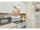 Bright kitchen features white cabinetry, tile backsplash, and modern appliances at 3004 Parkway Blvd # 203, Kissimmee, FL 34747