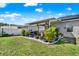 A wide view of a well manicured back yard featuring a covered patio and ample green space at 3086 Brenton Manor Loop, Winter Haven, FL 33881