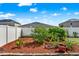 Well-maintained backyard featuring lush landscaping, a white privacy fence, and ample space for outdoor activities at 3086 Brenton Manor Loop, Winter Haven, FL 33881