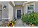 Inviting front entrance with a stylish black door, decorative plants, and stone accents at 3086 Brenton Manor Loop, Winter Haven, FL 33881