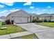 Well-maintained home features a gray exterior, two-car garage, and a wide driveway at 3086 Brenton Manor Loop, Winter Haven, FL 33881