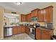 Functional kitchen featuring wood cabinets, stainless steel appliances, and tile floors at 3086 Brenton Manor Loop, Winter Haven, FL 33881