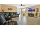 Spacious living room with comfortable leather furniture, tiled floors, and a modern ceiling fan at 3086 Brenton Manor Loop, Winter Haven, FL 33881
