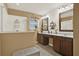 Bright bathroom featuring double vanity, glass enclosed shower and neutral tile at 3086 Brenton Manor Loop, Winter Haven, FL 33881