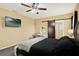 Cozy main bedroom with a ceiling fan, television and a barn door leading to the en suite bathroom at 3086 Brenton Manor Loop, Winter Haven, FL 33881