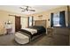 A bright, carpeted main bedroom features a ceiling fan, dark curtains, and furniture at 3086 Brenton Manor Loop, Winter Haven, FL 33881