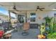 The patio is furnished with a table, chairs, ceiling fans, and several potted plants at 3086 Brenton Manor Loop, Winter Haven, FL 33881