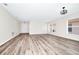 Expansive living room featuring continuous wood flooring, neutral paint, modern lighting, and multiple windows at 3156 Natoma Way, Orlando, FL 32825