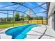 A serene pool area is surrounded by lush greenery and a screen enclosure at 3156 Natoma Way, Orlando, FL 32825