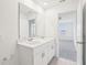 Bright white bathroom featuring double sinks, neutral flooring, and access to the primary bedroom at 3213 Viceroy Ct, Poinciana, FL 34759