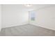 Clean, light-filled bedroom featuring neutral carpet, window with blinds, and freshly painted white walls at 3213 Viceroy Ct, Poinciana, FL 34759