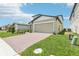 Beautiful home featuring a brick driveway, two-car garage, and well-maintained lawn at 3213 Viceroy Ct, Poinciana, FL 34759